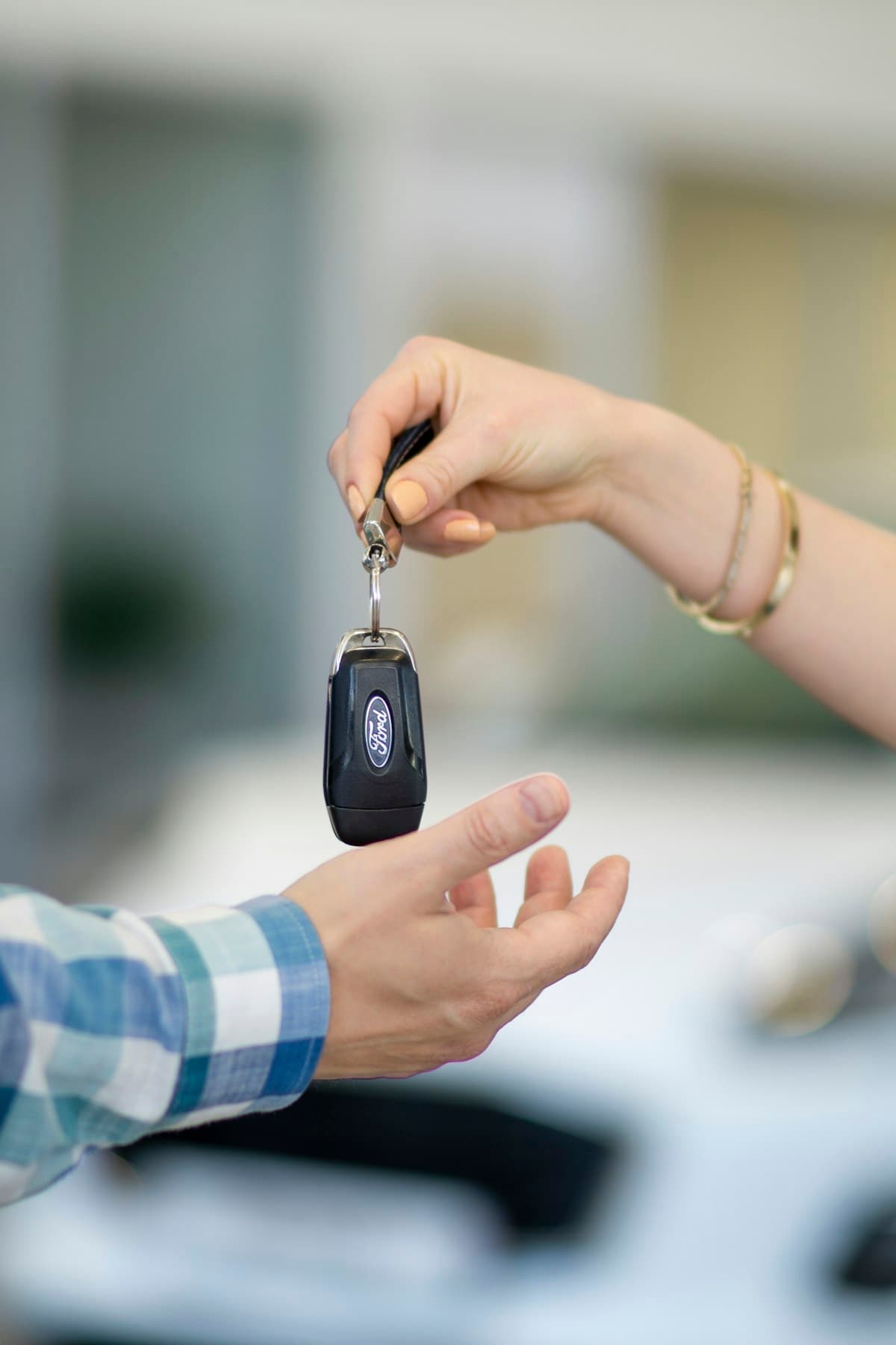 An agent handing car keys to a customer